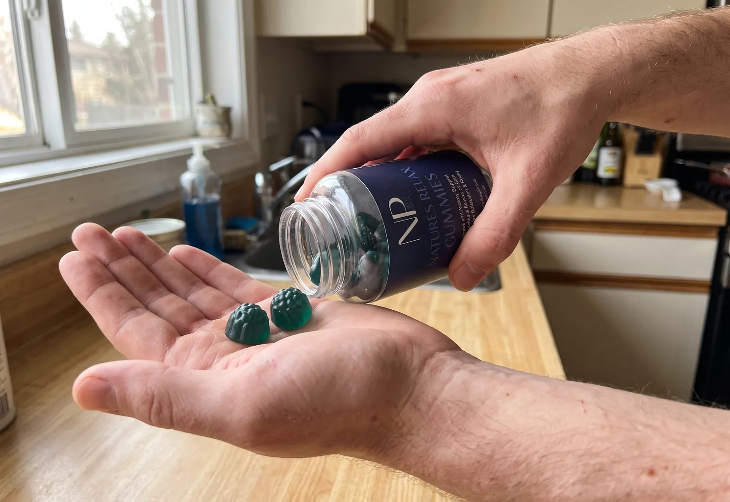 Two NarrowPath gummies held in an open palm beside the bottle