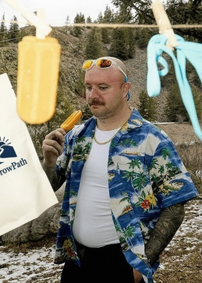 A man in a Hawaiian shirt enjoying an ice pop next to a NarrowPath Natures Relax pouch